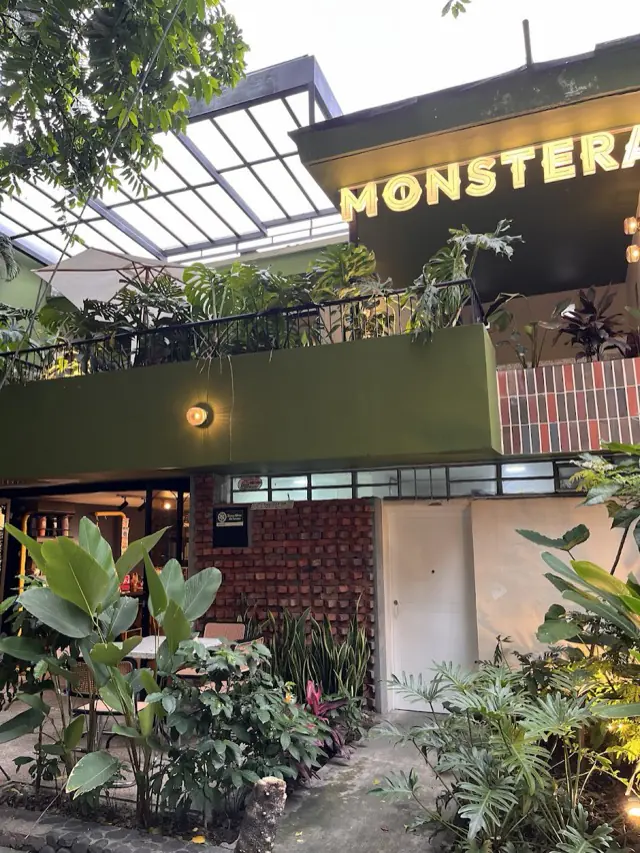Entrada de Monstera con su aviso, el balcón verde y muchas plantas