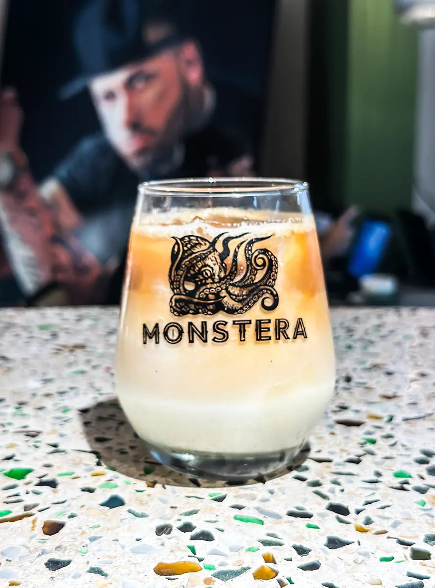 Latte frío en vaso con el logo de Monstera